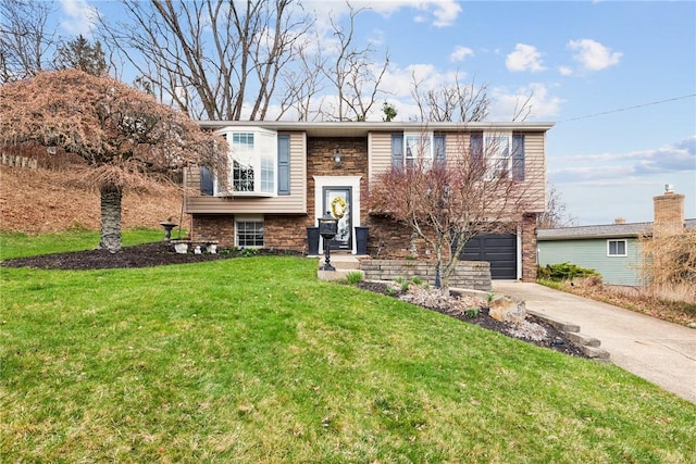 bi-level home featuring a front lawn, a garage, and concrete driveway