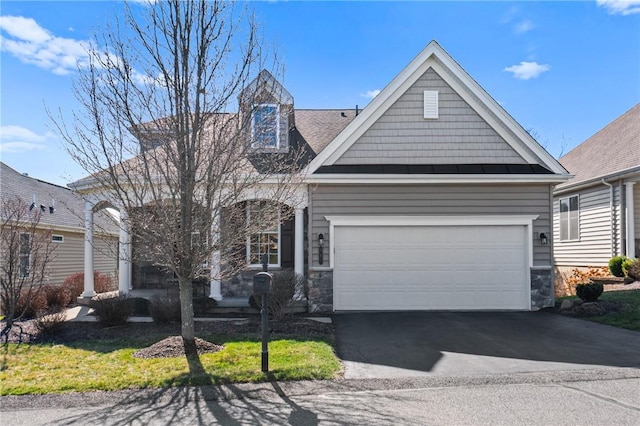 view of front of home featuring aphalt driveway, stone siding, and an attached garage