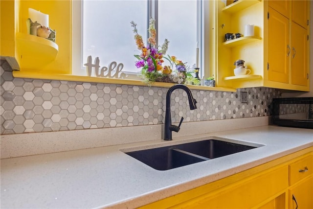 kitchen featuring decorative backsplash, a sink, and open shelves