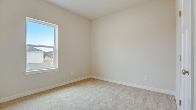empty room with baseboards and carpet flooring