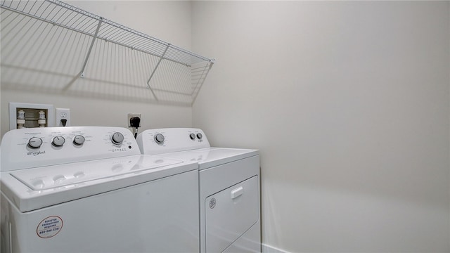 clothes washing area featuring separate washer and dryer and laundry area