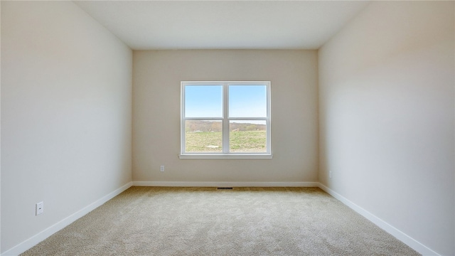 carpeted empty room with baseboards and visible vents