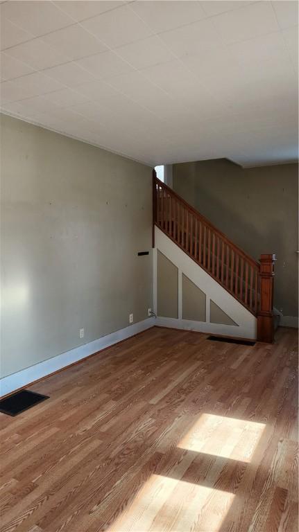 613 Terrace Ave, Grove City Boro, PA 16127 - unfurnished living room with stairs, visible vents, wood finished floors, and baseboards