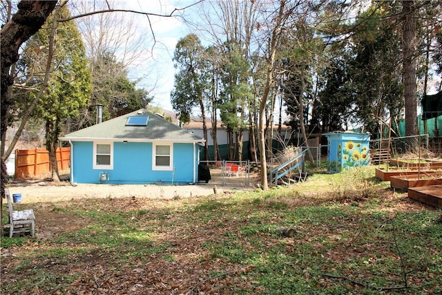 808 Thompson Run Rd, Springdale Twp, PA 15049 - rear view of property with a fenced backyard, an outdoor structure, a shingled roof, a storage shed, and a vegetable garden