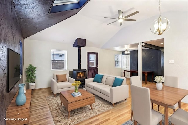 808 Thompson Run Rd, Springdale Twp, PA 15049 - living area featuring a wood stove, light wood-style floors, lofted ceiling, a ceiling fan, and a skylight