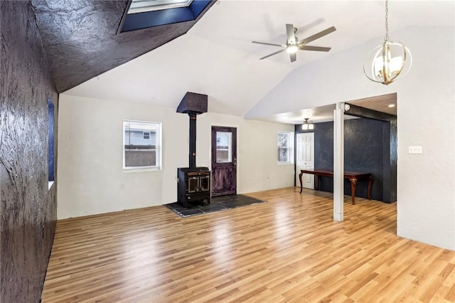 808 Thompson Run Rd, Springdale Twp, PA 15049 - unfurnished living room with wood finished floors, lofted ceiling, a wood stove, a skylight, and a chandelier