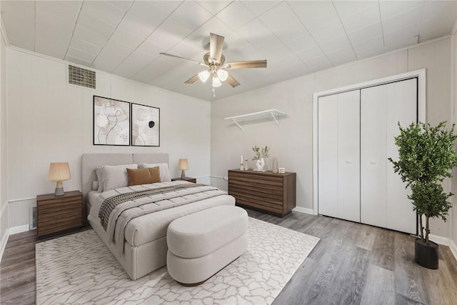 bedroom featuring a closet, visible vents, ceiling fan, and wood finished floors