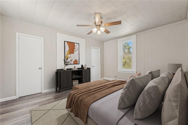 bedroom with baseboards, wood finished floors, and a ceiling fan