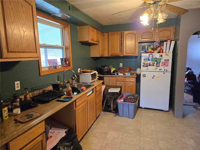 104 Forrest St, Petrolia, PA 16050 - kitchen featuring a sink, a ceiling fan, freestanding refrigerator, light floors, and arched walkways