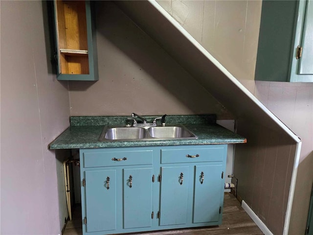 104 Forrest St, Petrolia, PA 16050 - kitchen with dark countertops, a sink, blue cabinets, and dark wood-style floors
