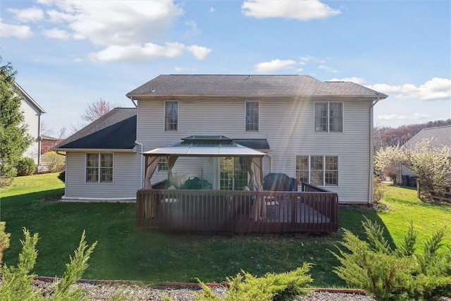 rear view of house with a gazebo, a yard, and a deck