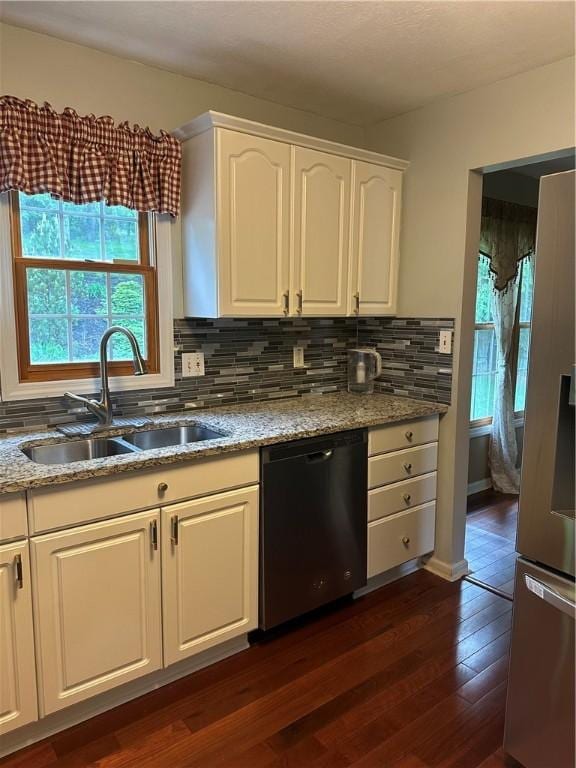 kitchen featuring dishwasher, a sink, stainless steel refrigerator with ice dispenser, dark wood finished floors, and backsplash
