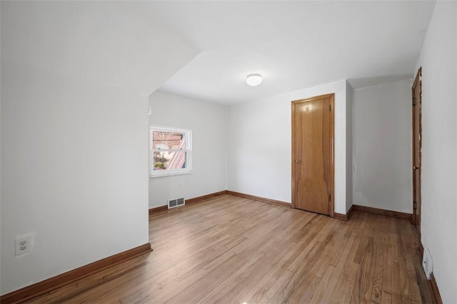 spare room with light wood-style floors and baseboards