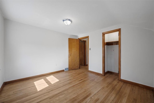 unfurnished bedroom with light wood-style floors, a closet, and baseboards