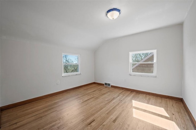 additional living space with lofted ceiling, wood finished floors, and baseboards