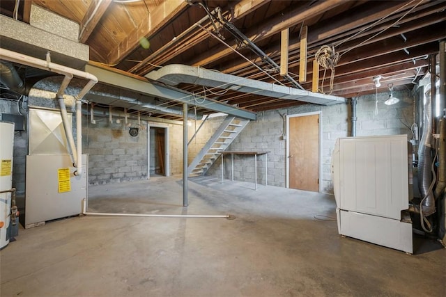 unfinished below grade area featuring stairway, heating unit, and water heater