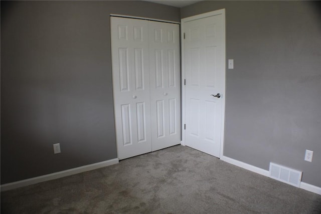 unfurnished bedroom with carpet flooring, a closet, and baseboards