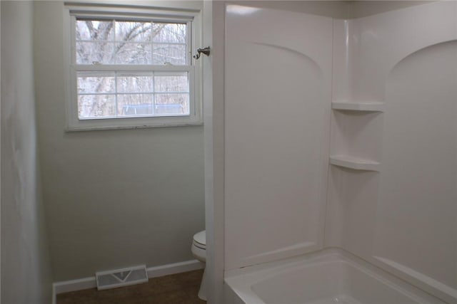 full bathroom featuring toilet, baseboards, and shower / bath combination