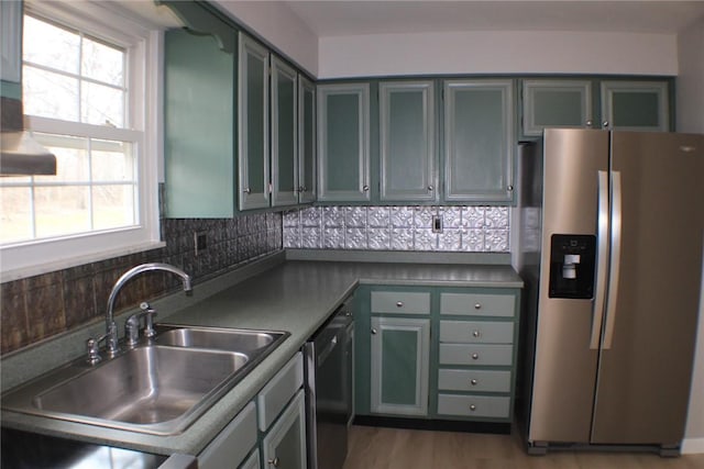 kitchen featuring appliances with stainless steel finishes, a sink, healthy amount of natural light, and tasteful backsplash
