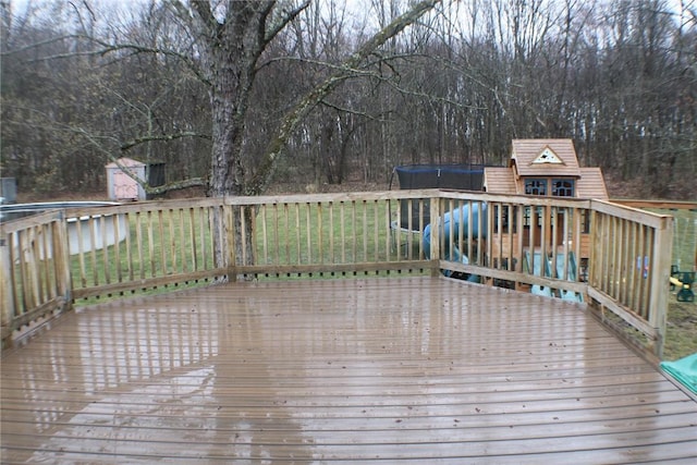 wooden deck with an outbuilding, a storage shed, and a wooded view