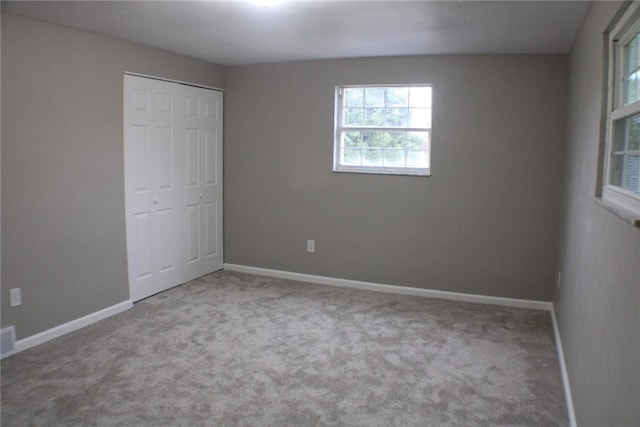unfurnished bedroom featuring carpet flooring, a closet, and baseboards