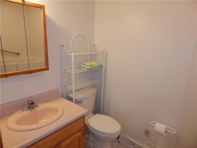 bathroom with vanity, toilet, and visible vents