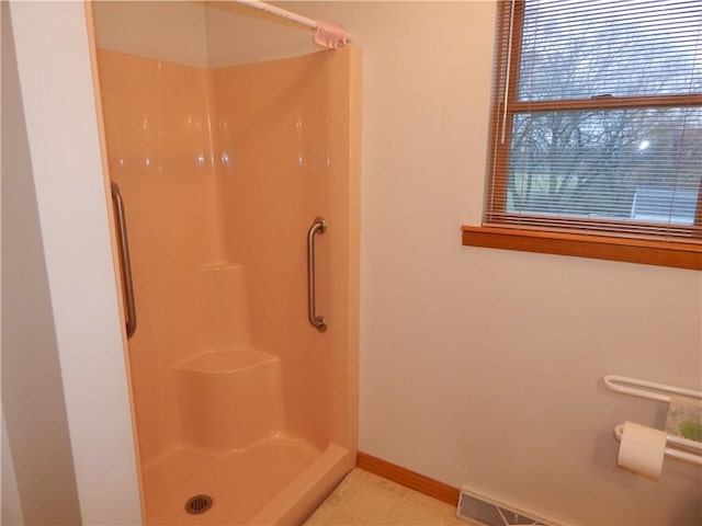 full bathroom featuring baseboards and a shower stall