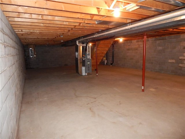 unfinished below grade area featuring heating unit and stairway