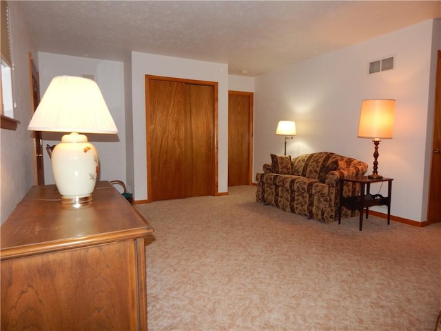 living area with visible vents and carpet flooring
