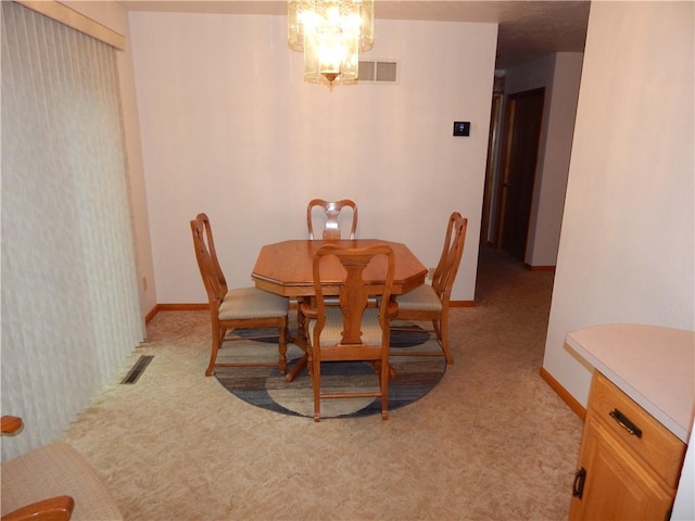 dining room featuring baseboards, light colored carpet, an inviting chandelier, and visible vents
