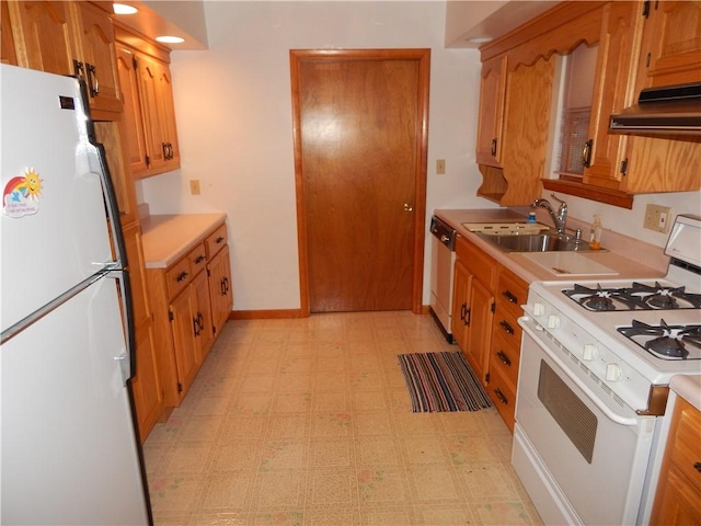kitchen with white appliances, light floors, light countertops, under cabinet range hood, and a sink