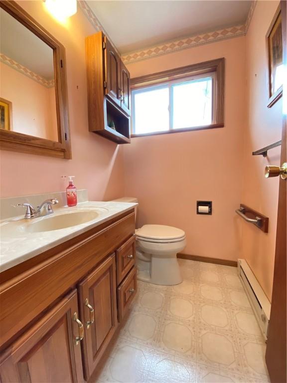 7005 N Dr, Shenango-Cra, PA 16134 - bathroom featuring a baseboard heating unit, toilet, vanity, and tile patterned floors