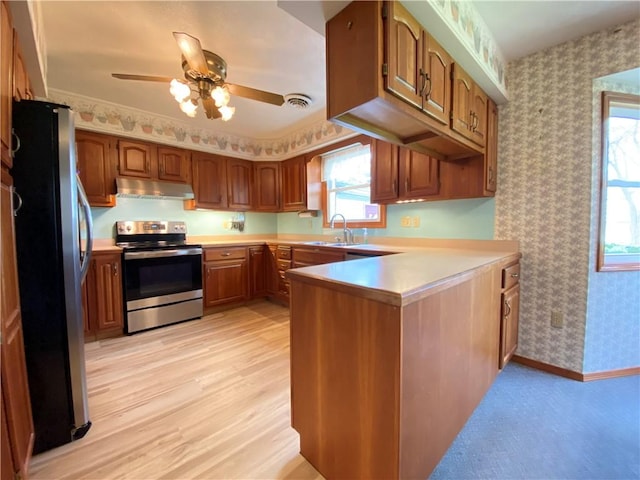 7005 N Dr, Shenango-Cra, PA 16134 - kitchen with appliances with stainless steel finishes, under cabinet range hood, wallpapered walls, a peninsula, and a sink