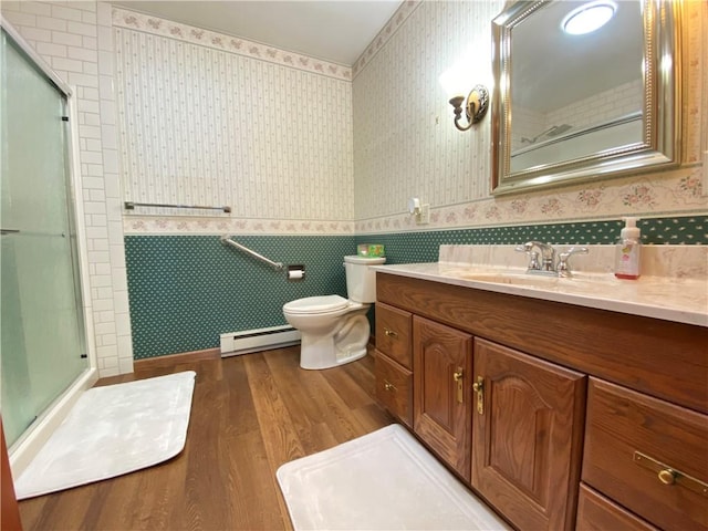 7005 N Dr, Shenango-Cra, PA 16134 - bathroom with a baseboard heating unit, wallpapered walls, wood finished floors, vanity, and toilet
