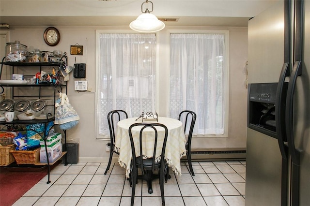 dining space with a baseboard radiator, light tile patterned floors, baseboards, and visible vents