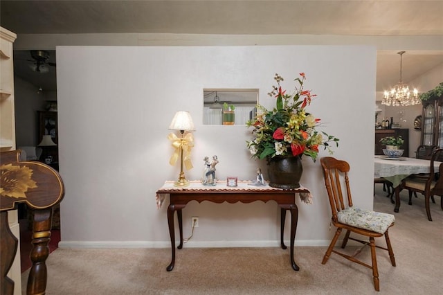 interior space with an inviting chandelier, carpet floors, and baseboards