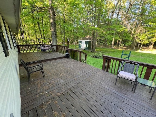 wooden deck featuring a storage shed, a yard, and an outdoor structure