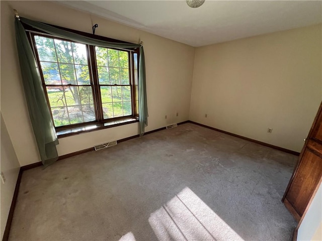 carpeted spare room featuring baseboards