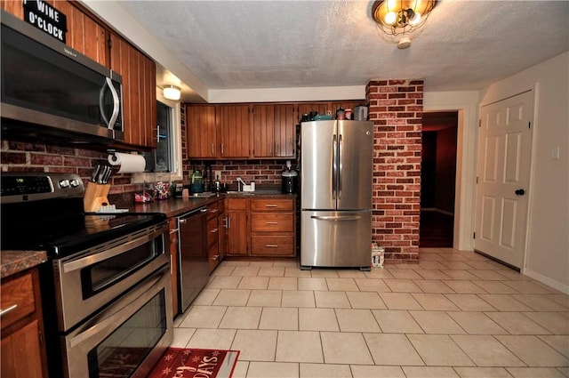 120 Scottsdale Dr, Moon/Crescent Twp, PA 15108 - kitchen featuring stainless steel appliances, dark countertops, brown cabinetry, and light tile patterned flooring