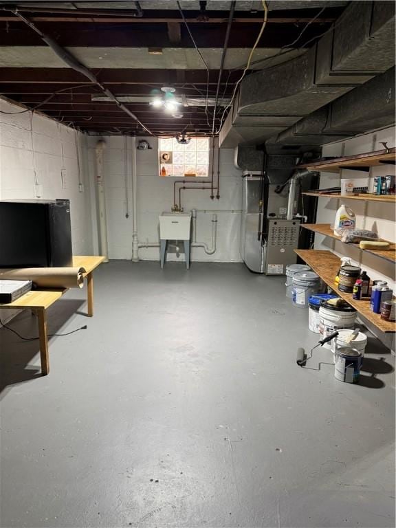 basement featuring heating unit and a sink