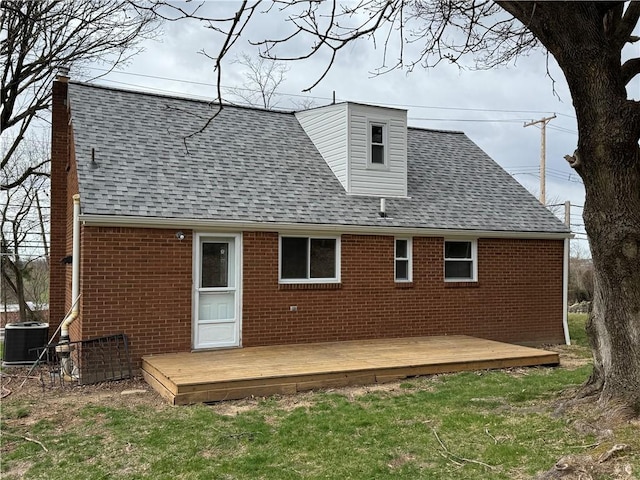 rear view of property with brick siding and roof with shingles