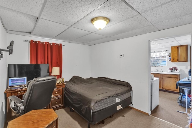 bedroom with light carpet, a sink, and a paneled ceiling