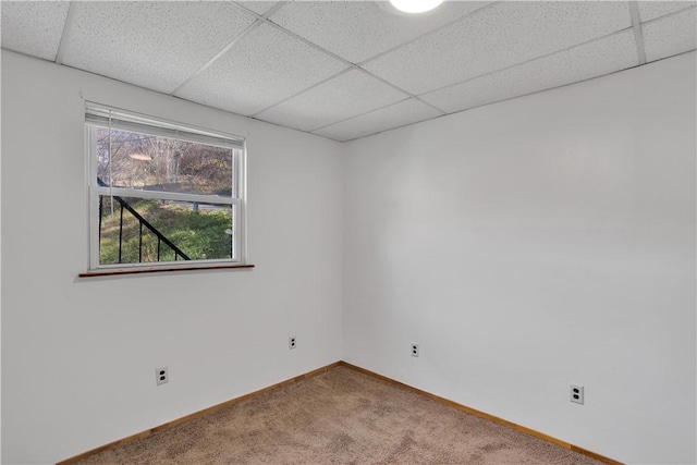 empty room with baseboards, carpet flooring, and a paneled ceiling