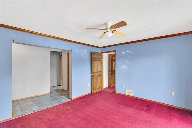 unfurnished room with crown molding, baseboards, carpet floors, ceiling fan, and visible vents
