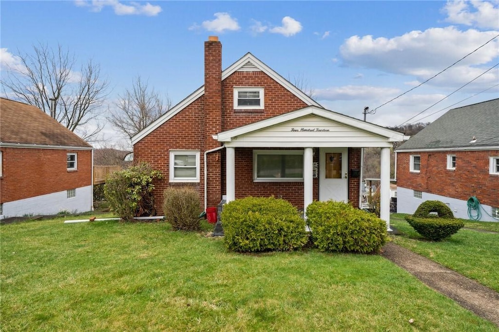 414 Mary St, Jeannette, PA 15644 - bungalow-style home with brick siding, a chimney, and a front lawn
