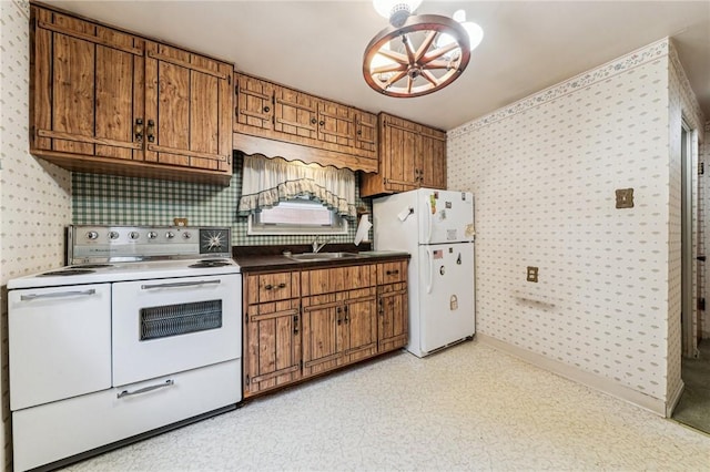 kitchen with an inviting chandelier, wallpapered walls, and white appliances