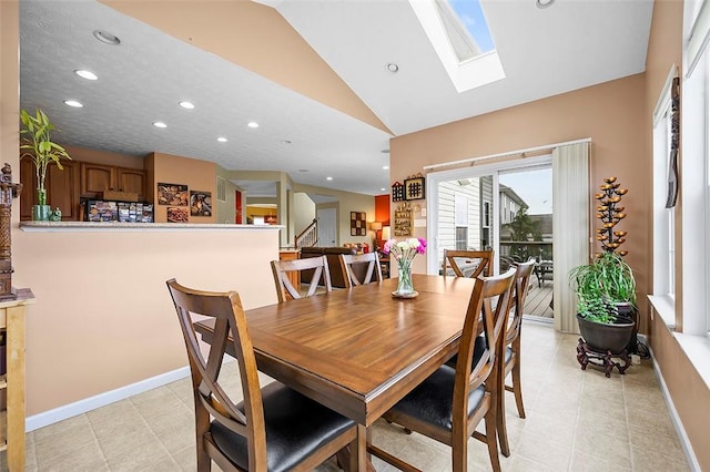 dining room featuring recessed lighting, baseboards, lofted ceiling with skylight, and light tile patterned floors