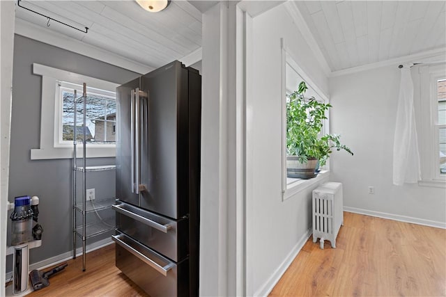 interior space featuring wood finished floors, radiator heating unit, crown molding, and plenty of natural light