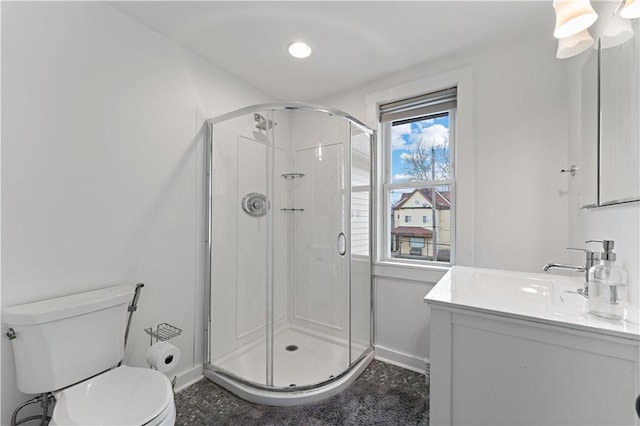 full bath featuring vanity, baseboards, toilet, and a shower stall
