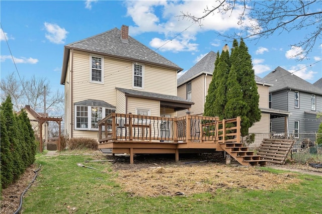 rear view of property featuring a chimney, a yard, and a wooden deck